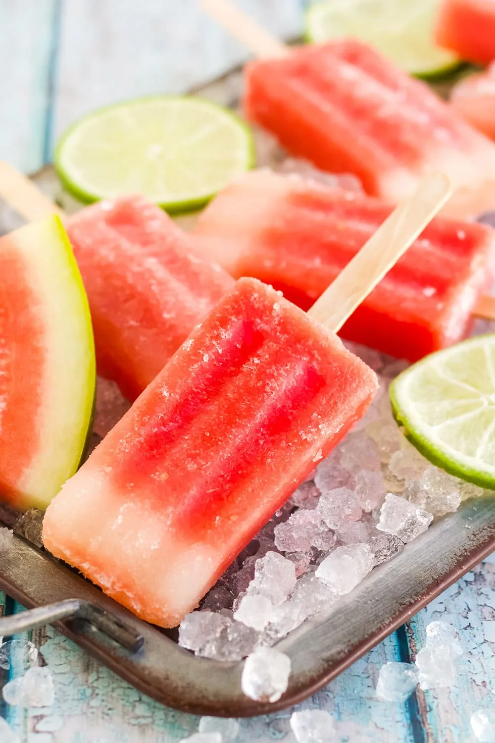 Red popsicles on a tray with watermelon.