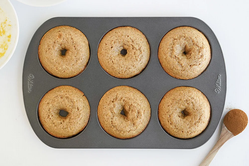Donuts in a pan after being baked.