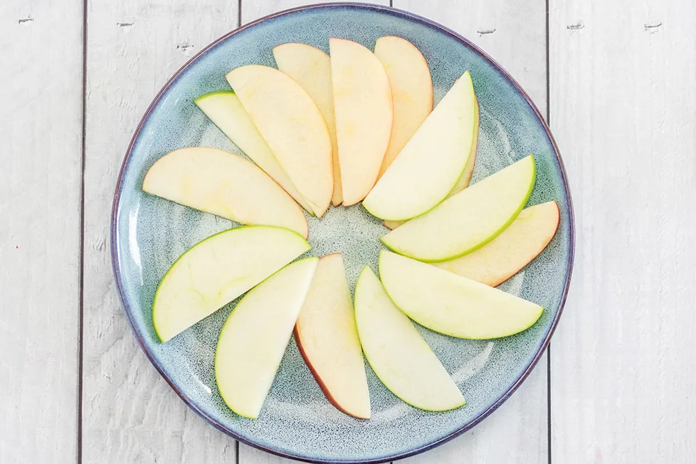 Apple slices arranged on a blue plate.