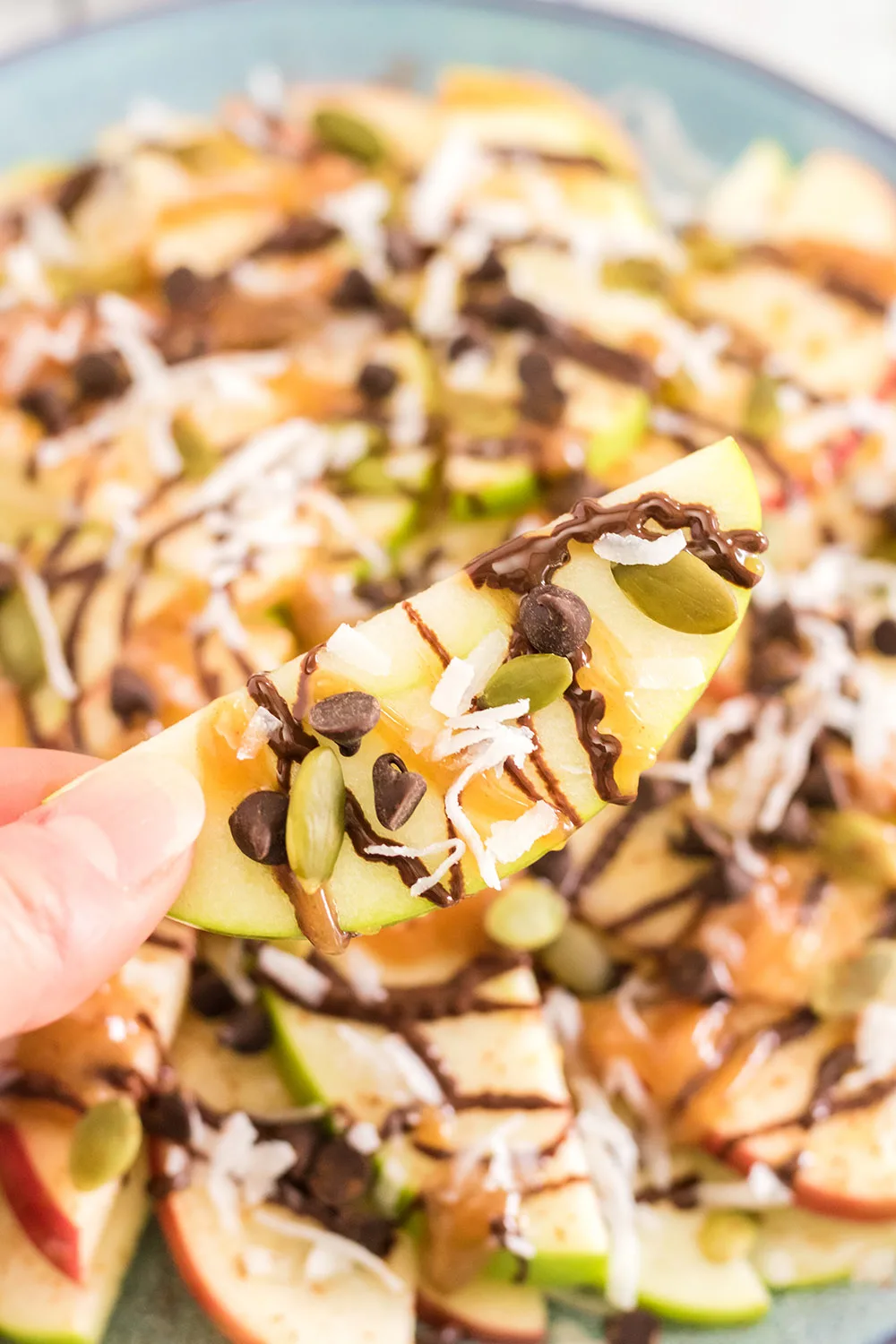Apples topped with nuts, caramel, and chocolate for apple nachos.