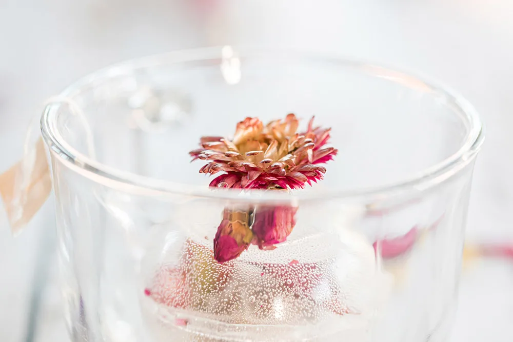 Half of a clear tea orb with a flower in it.