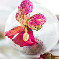 Clear tea globe with a pink flower.