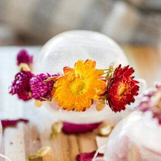 Clear tea orb with flowers around it.