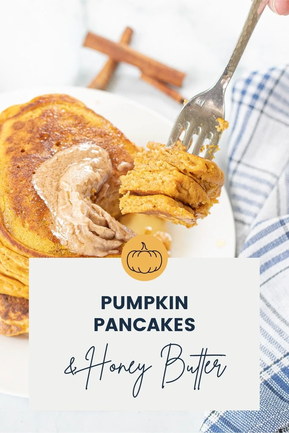 Forkfull of pancakes over a plate of pumpkin pancakes.