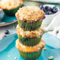 Three muffin stacked on top of each other on a blue plate.