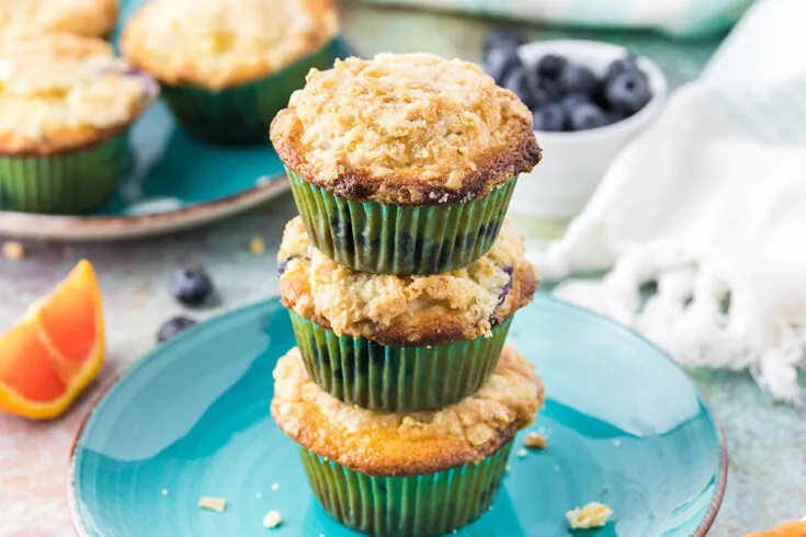 Three muffin stacked on top of each other on a blue plate.