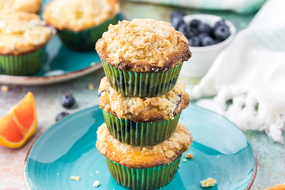 Three muffin stacked on top of each other on a blue plate.