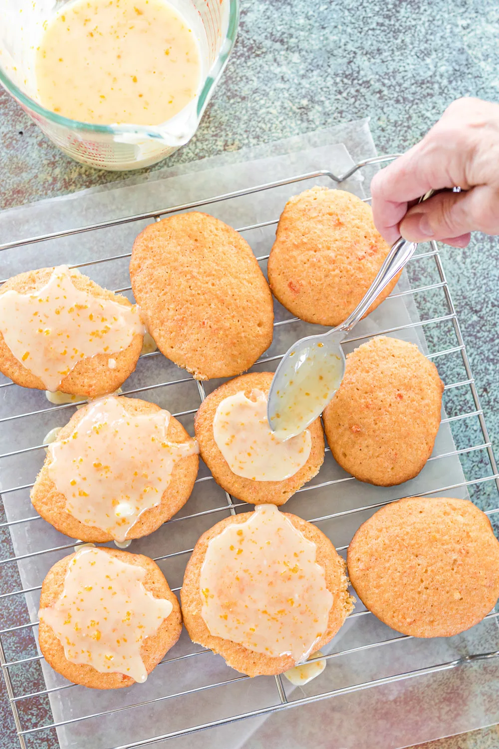 Adding glaze to orange carrot cookies. 