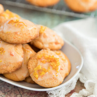 Carrot cookies with an orange glaze on a tray.