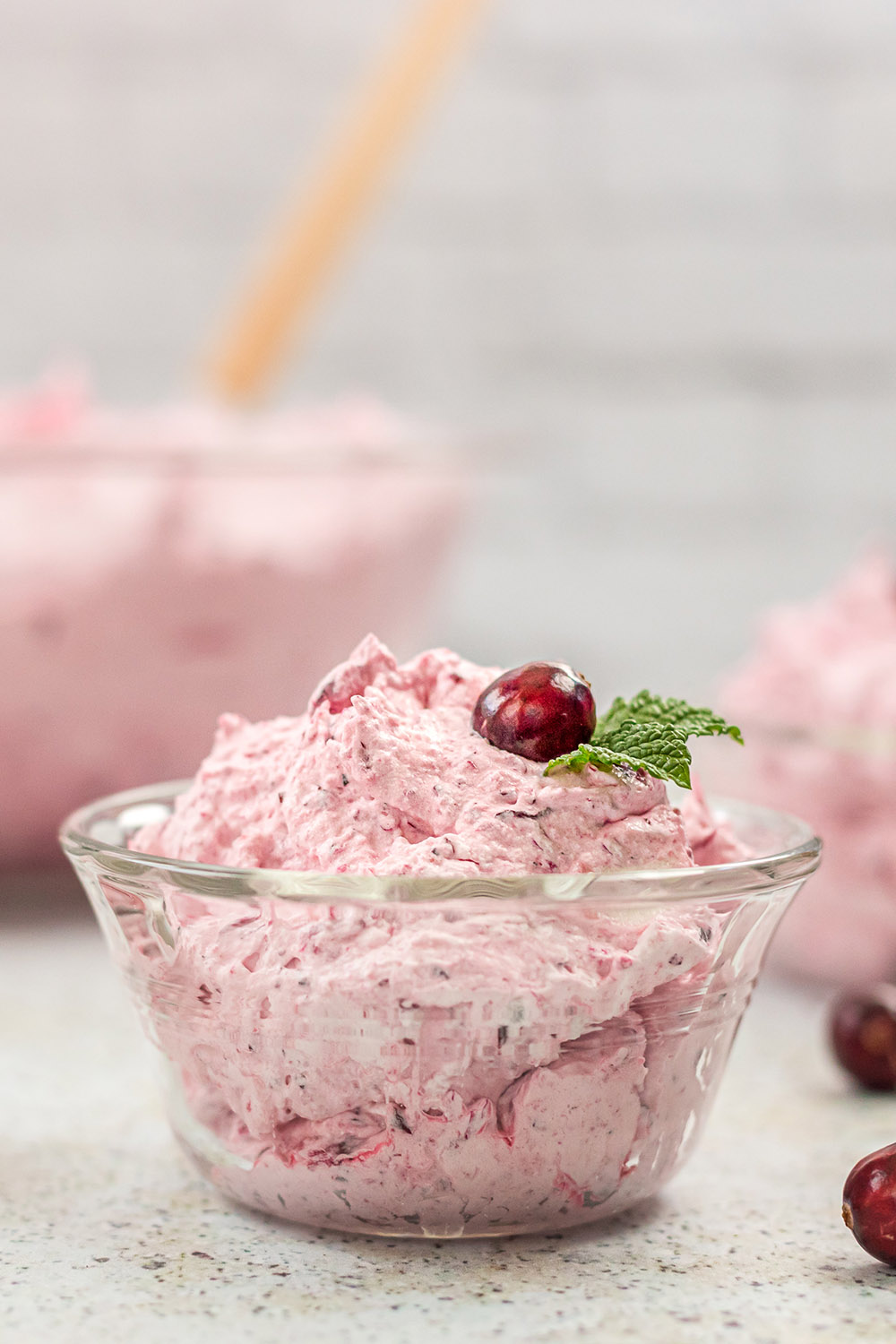 Pink whipped cranberry salad in a clear bowl.