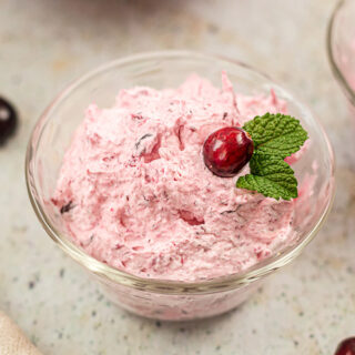 A clear bowl filled with pink fluffy cranberry salad.