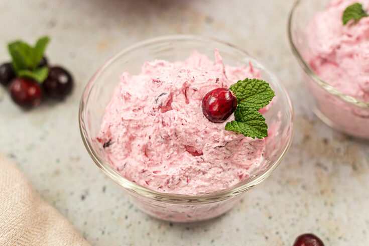 A clear bowl filled with pink fluffy cranberry salad.