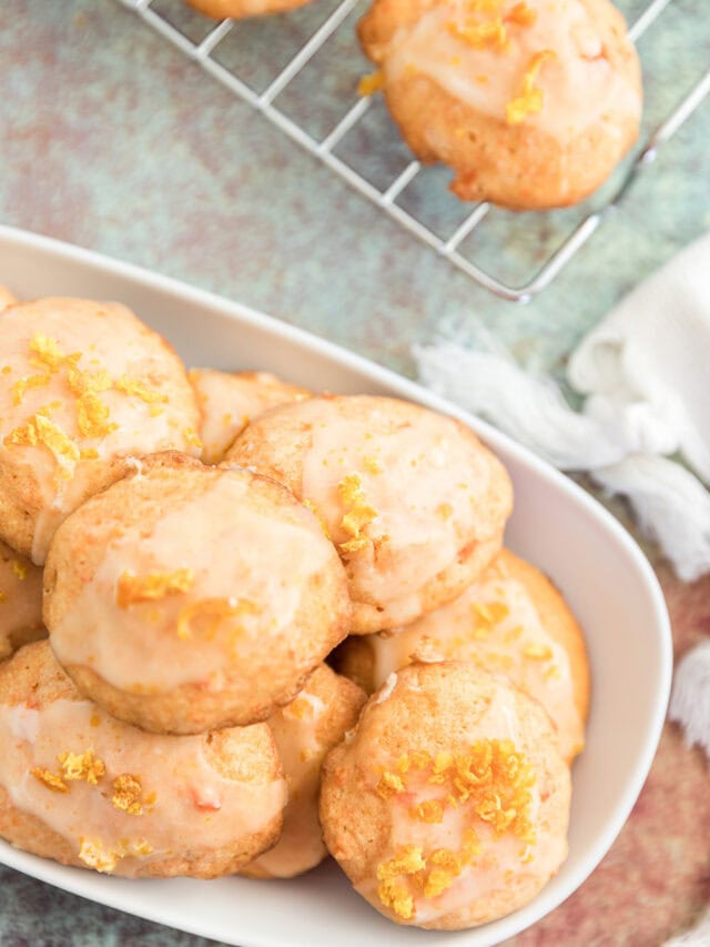 Overhead shot of carrot orange cookies on a rack and on a tray.