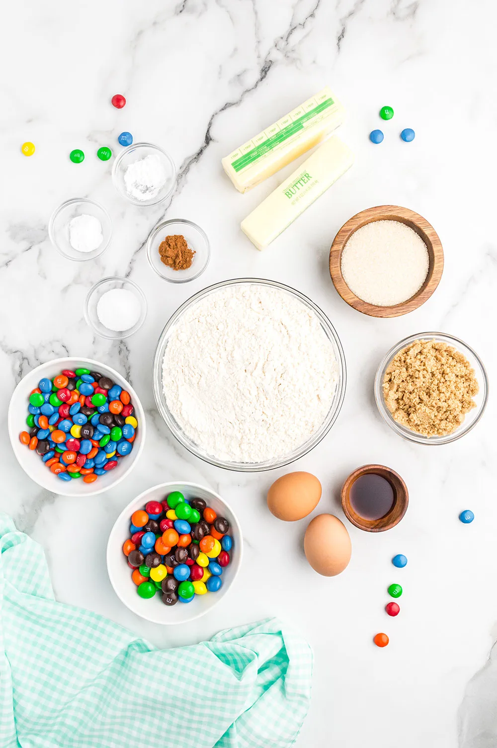 Butter, flour, M&M candies, eggs, and other ingredients to make cookies. 