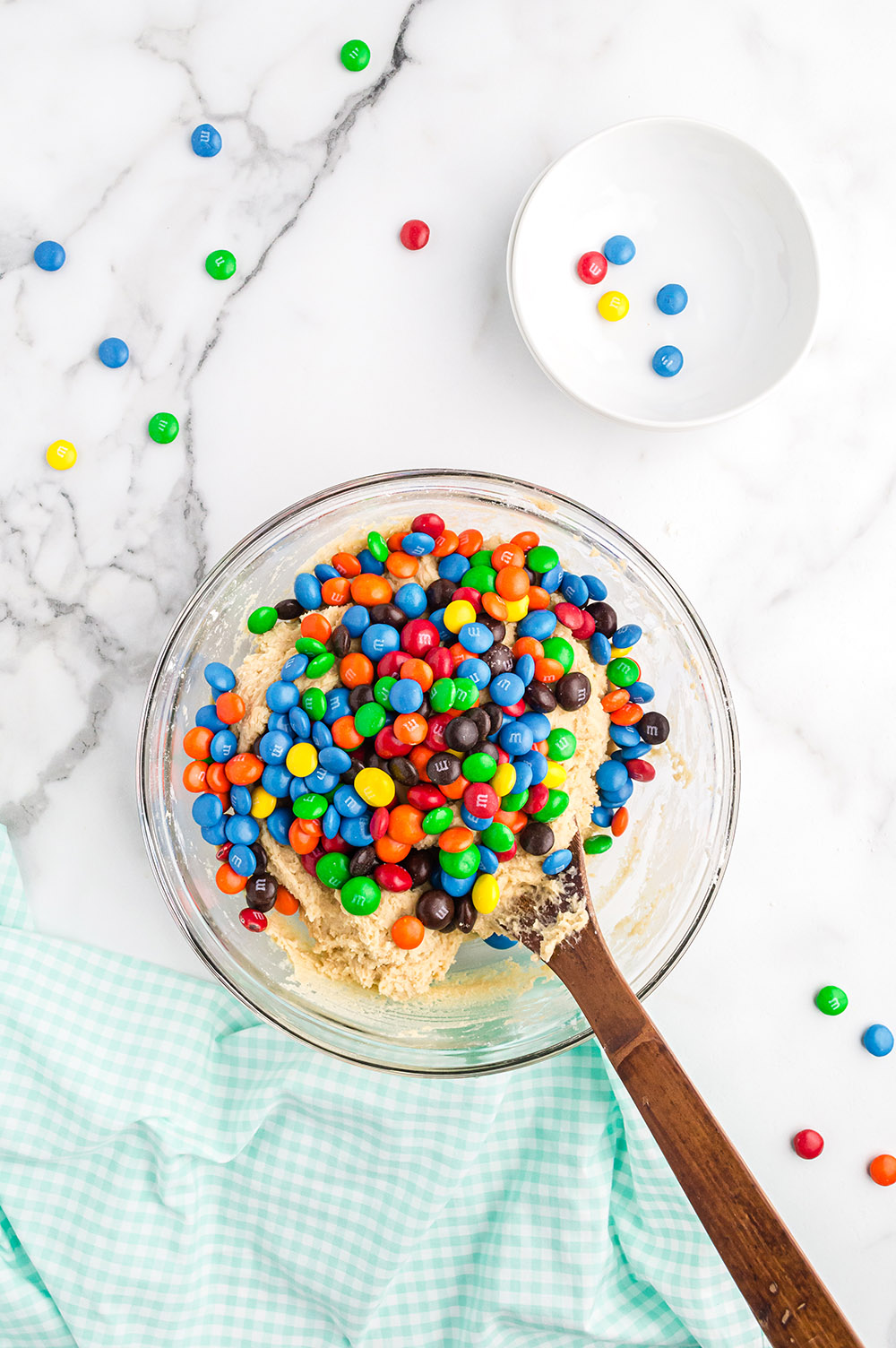 M&M's in a mixing bowl with cookie batter. 