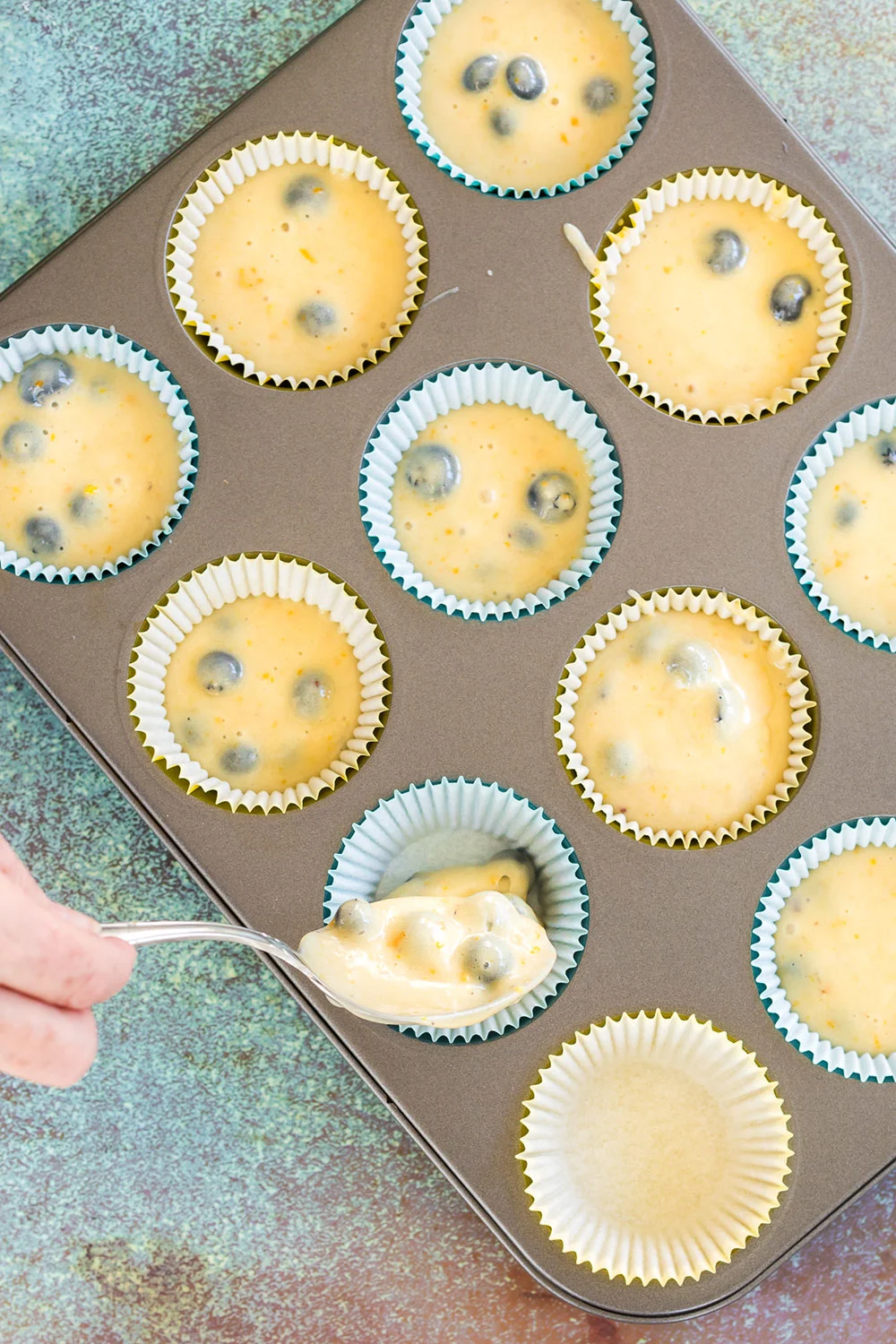 Filling muffin liners with batter.