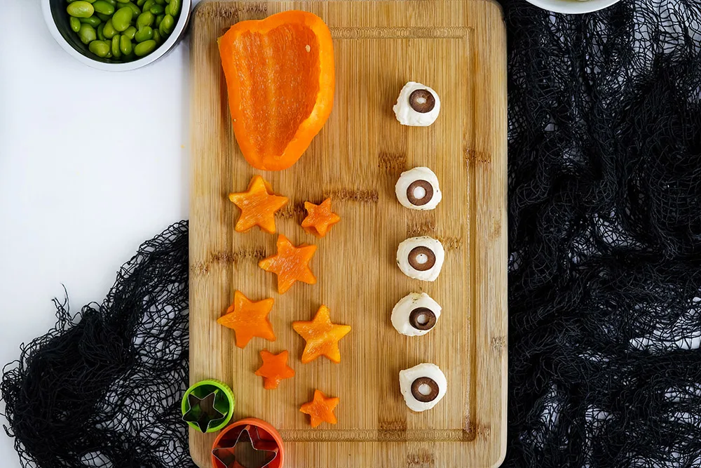 Cut peppers into star shapes and making mozzarella balls that look like eyeballs with olives.