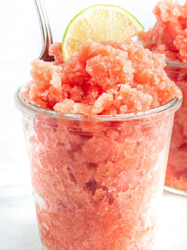 Clearn cup full of watermelon granita topped with a lime slice.