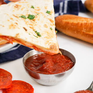 Dipping a pizza quesadilla into pizza sauce.