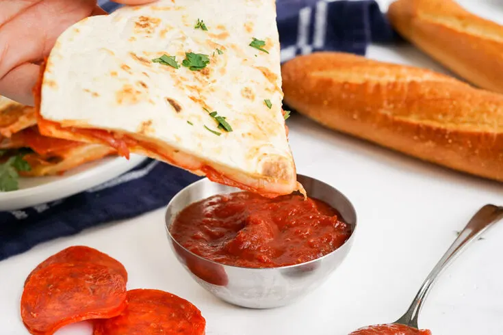 Dipping a pizza quesadilla into pizza sauce.