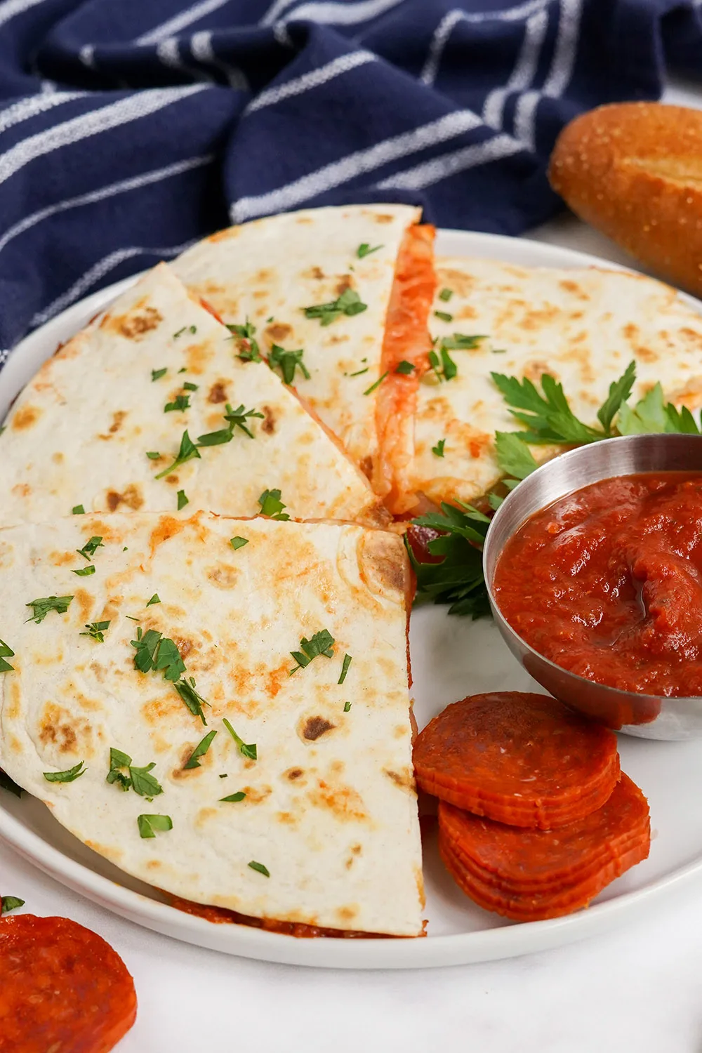 Pizza quesadillas on a plate with sauce. 