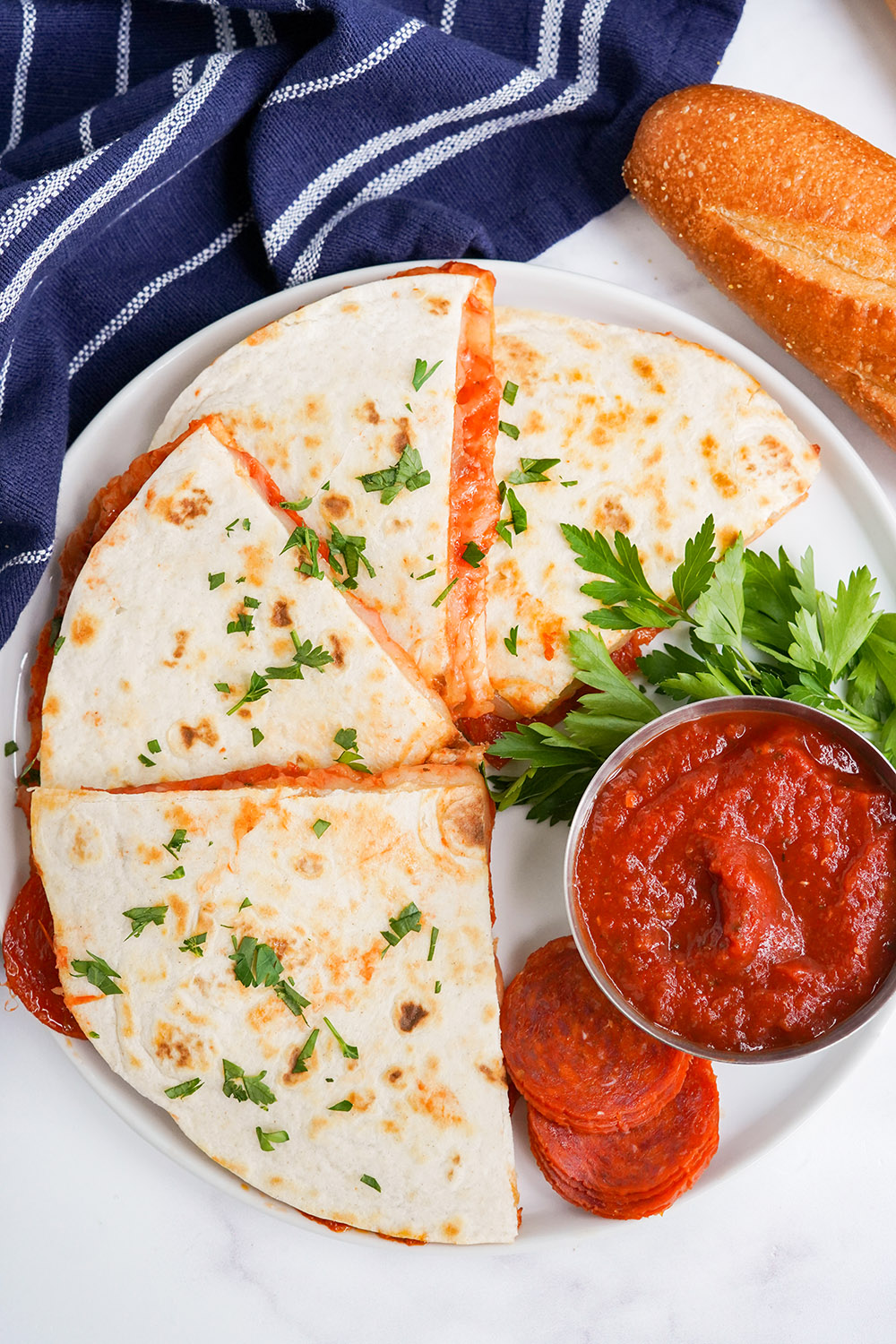 Sliced quesadillas on a plate with dipping sauce. 