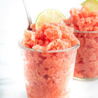 Watermelon lime granita in a cup with a spoon in it.