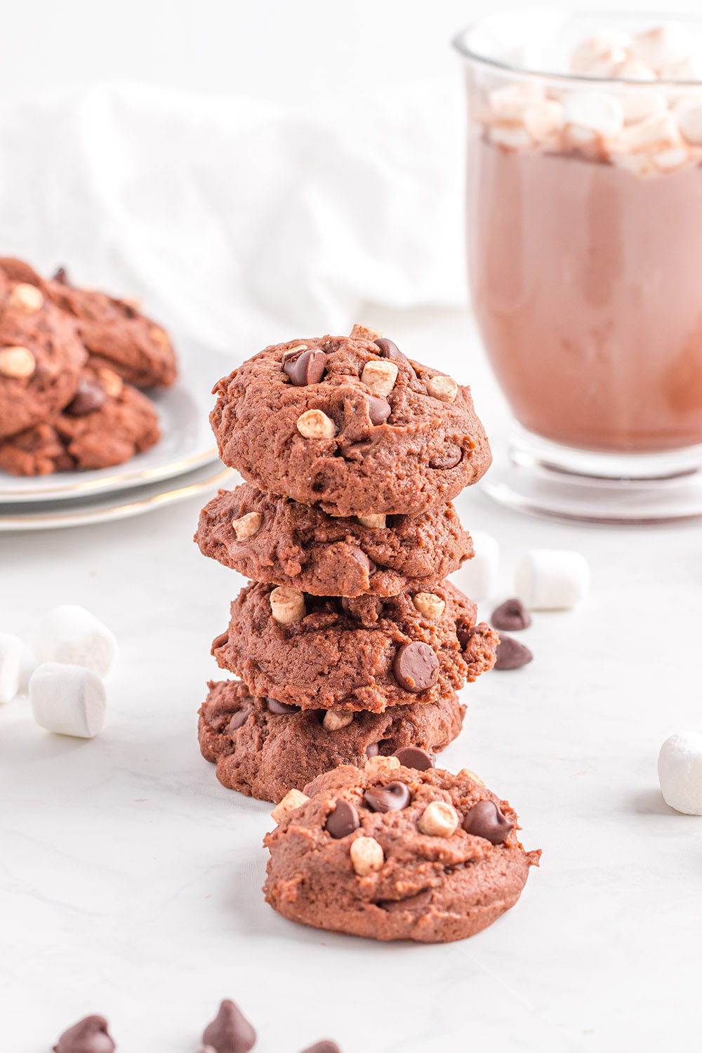 Stack of hot chocolate cookies with plate and mug on the table. 