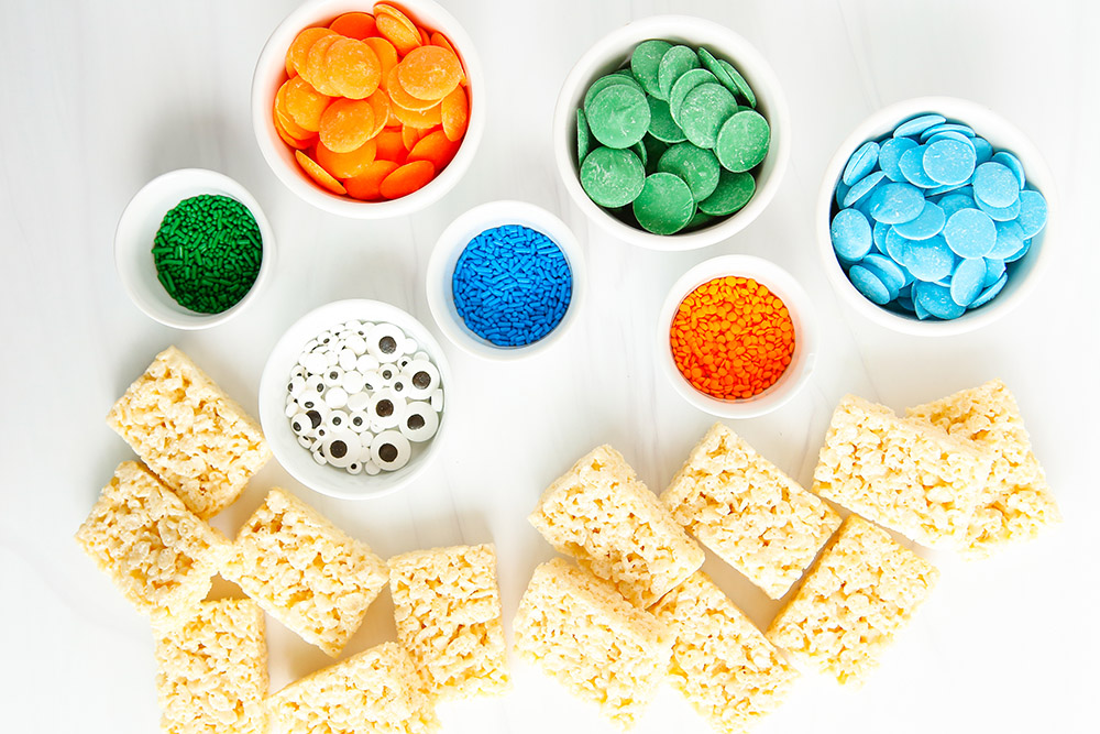 Rice krispie treats, candy melts, and candy eyes on a table. 