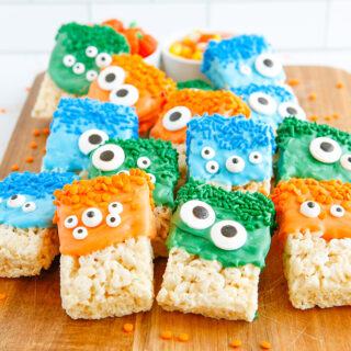 Rice Krispies treats decorated as monsters lined up on a board.