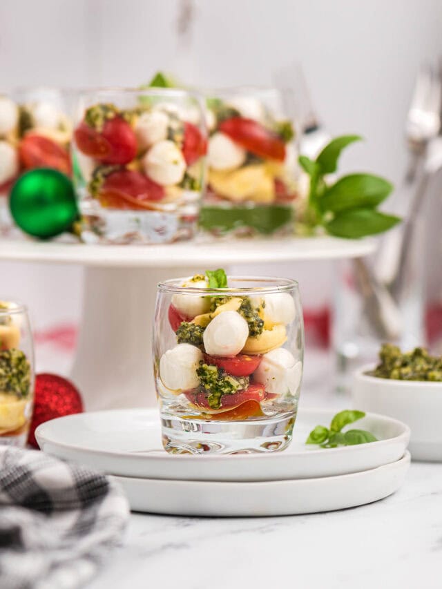 Glasses of caprese salad on a plate and on a serving dish.