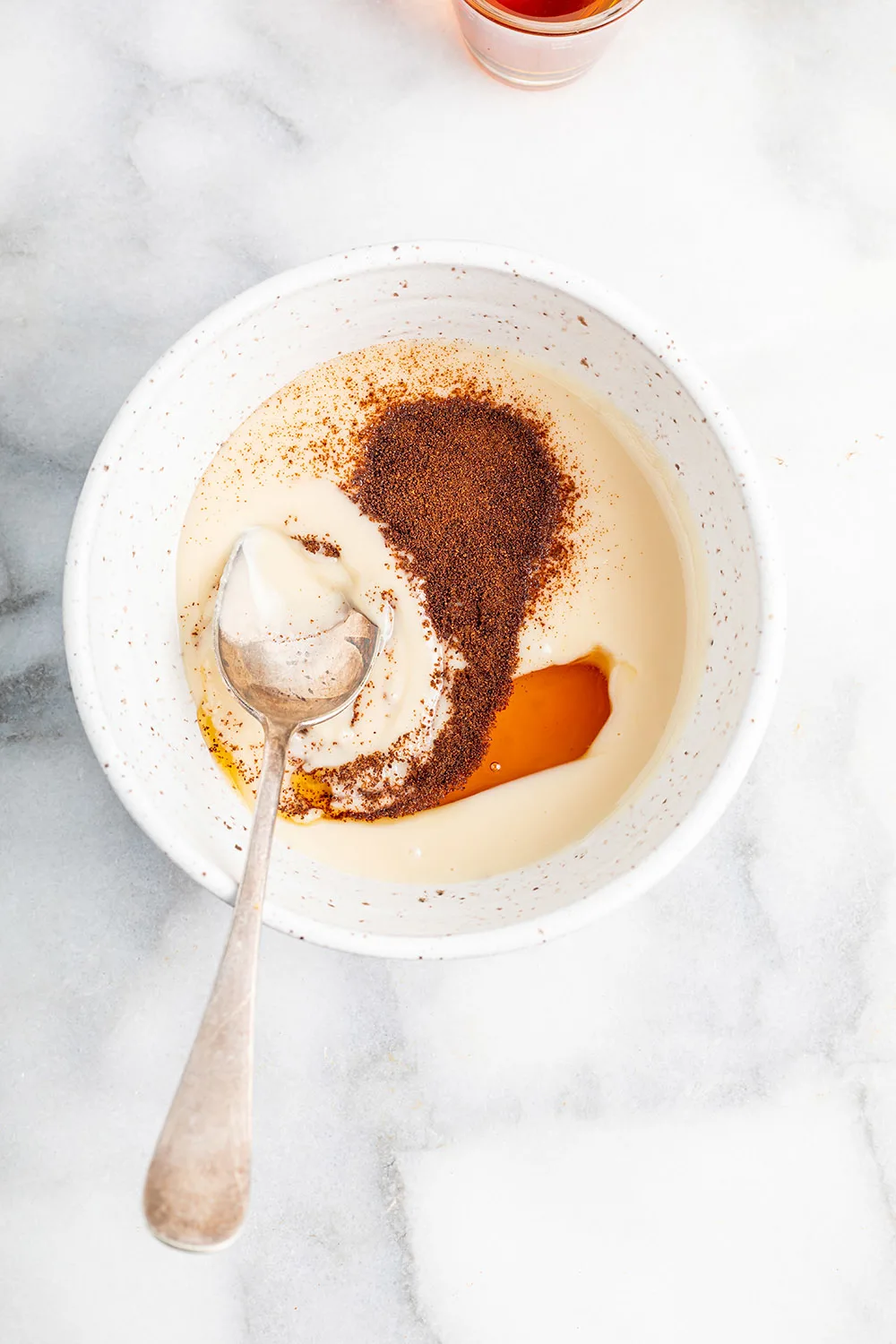 Coffee powder, coconut, butter, and maple syrup in a bowl. 