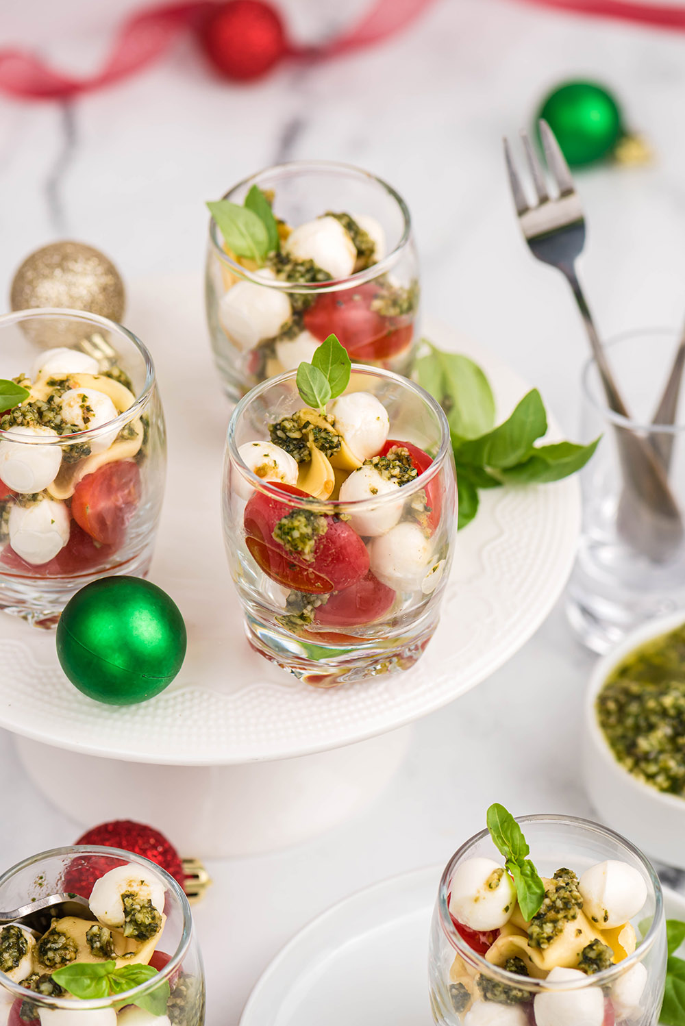 Shooter glasses of caprese salad on plate with ornaments. 
