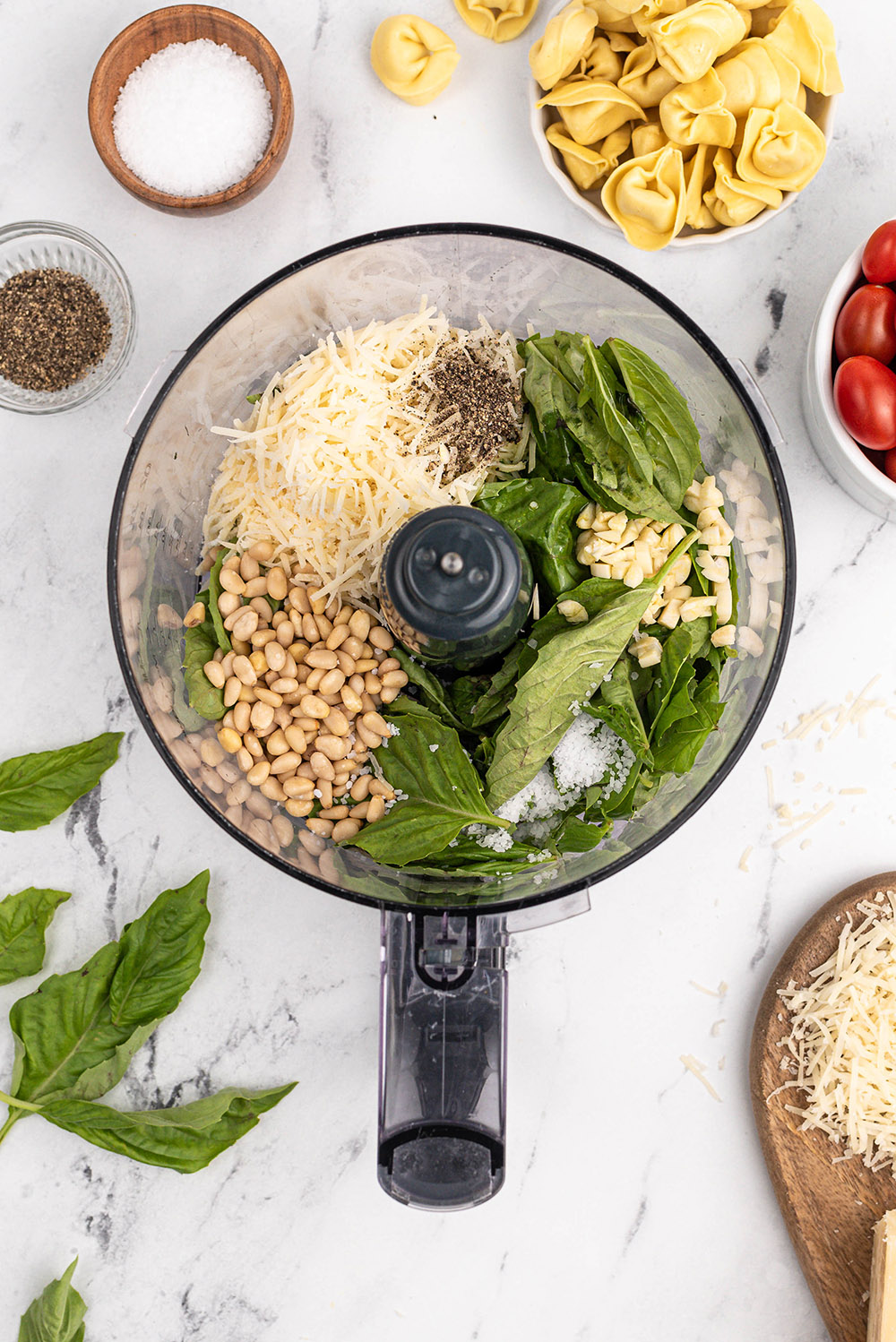 Pine nuts, basil, and cheese in a food processor. 
