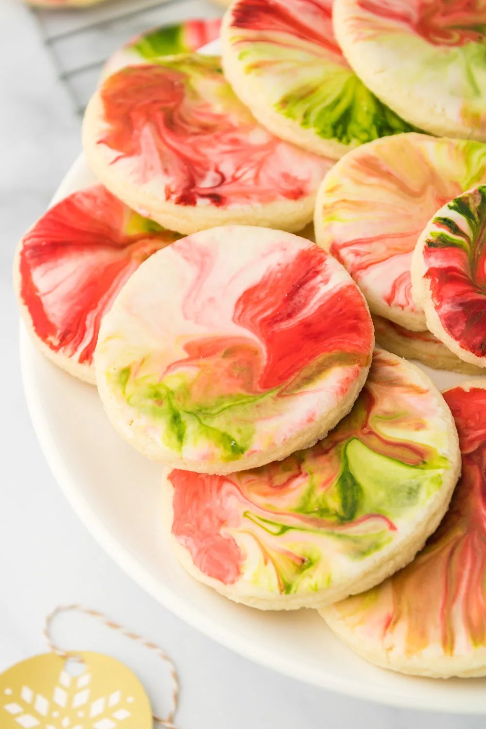 Plate full of swirled red and green iced holiday cookies.
