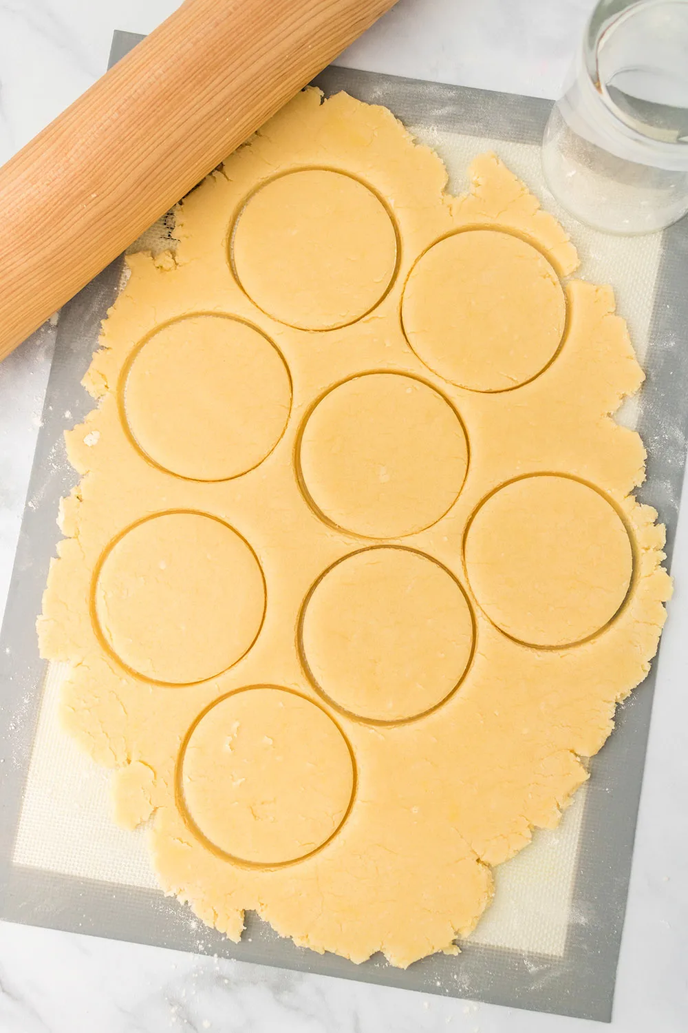 Rolled out sugar cookie dough cut into circles. 