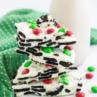 Stack of OREO bark next to a glass of milk and a green napkin.