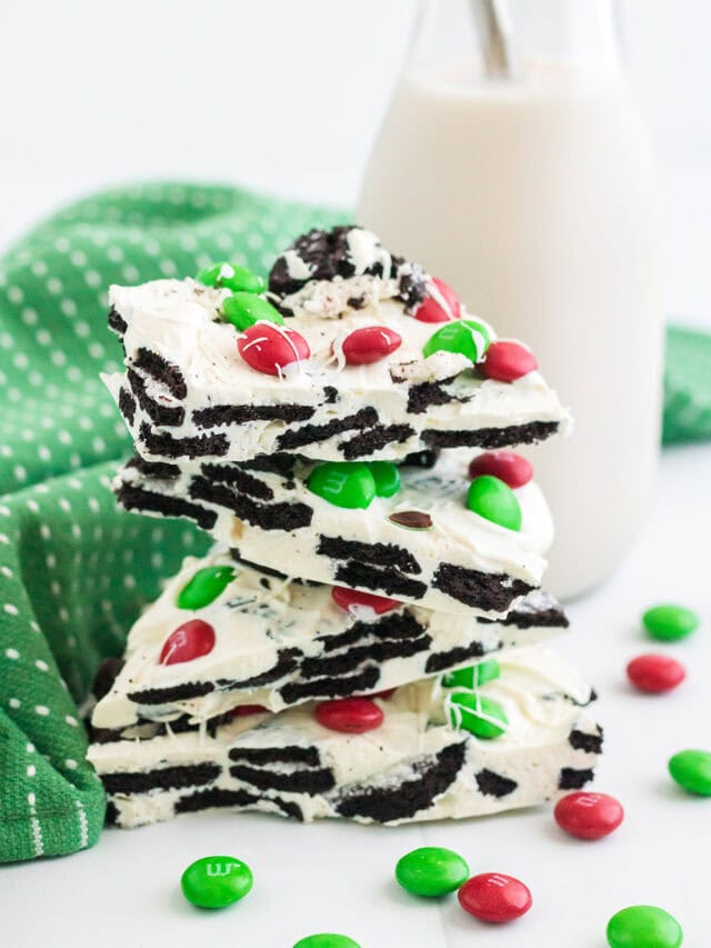 Stack of OREO bark next to a glass of milk and a green napkin.