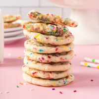 Stack of funfetti cookies with more on a stand in the background.