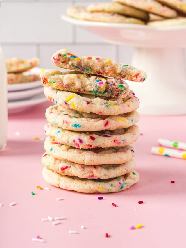 Stack of funfetti cookies with more on a stand in the background.