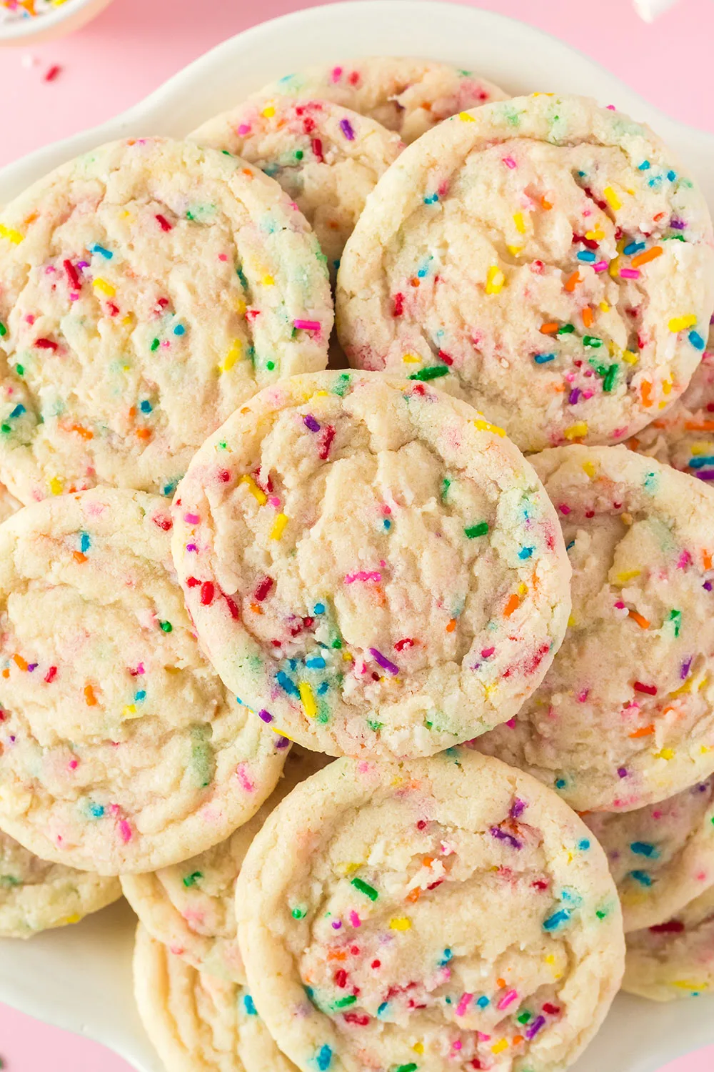 Zoomed in on a plate of sugar cookies with sprinkles. 