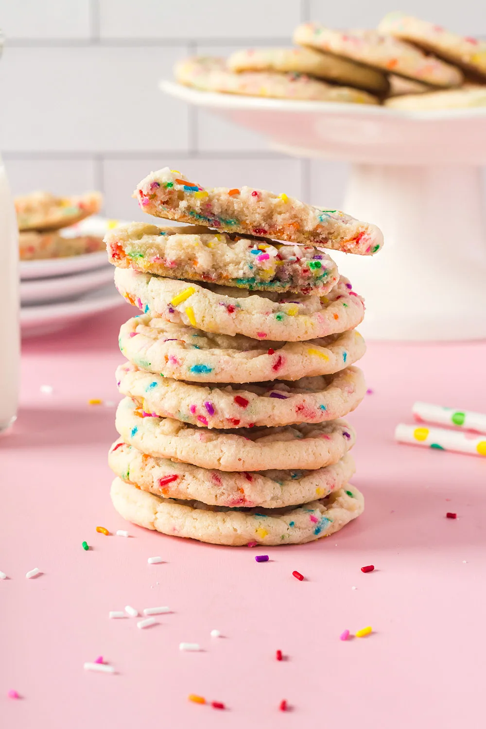Stack of funfetti cookies with more on a stand in the background. 