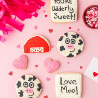 Decorated Valentine cow cookies on a table.