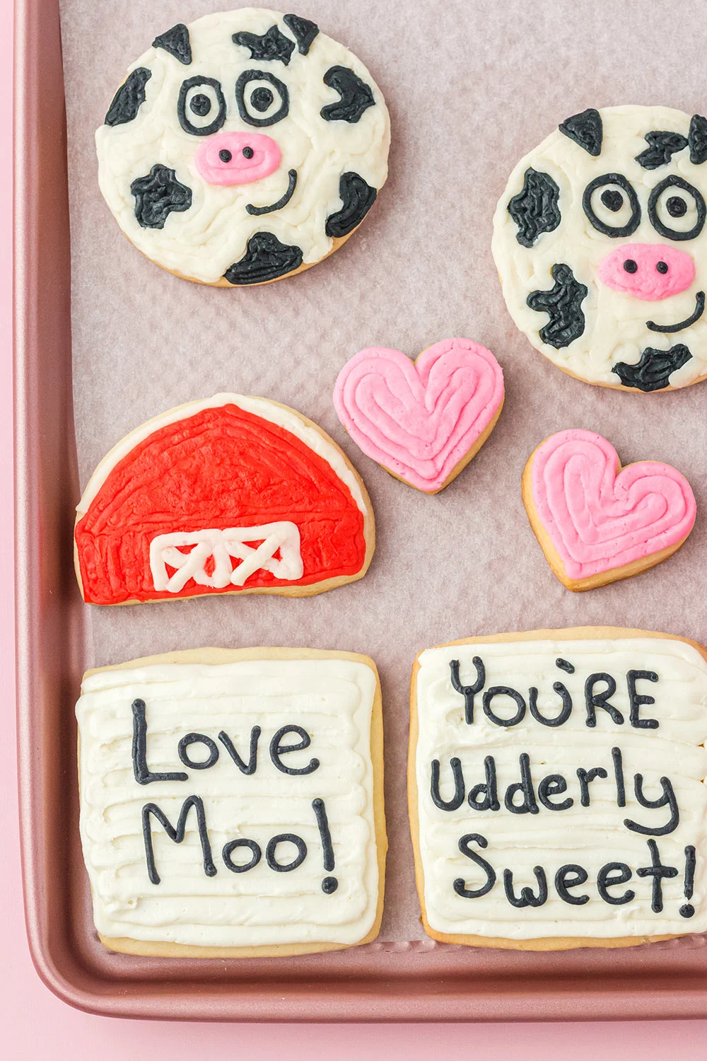 Cow, barn, heart, Love Moo, and You're Udderly Sweet decorated cookies on a sheet. 