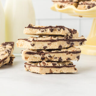 Cookie dough bark candy stacked and on a yellow candy dish.