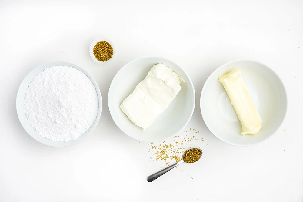 Butter, cream cheese, and other frosting ingredients in bowls. 
