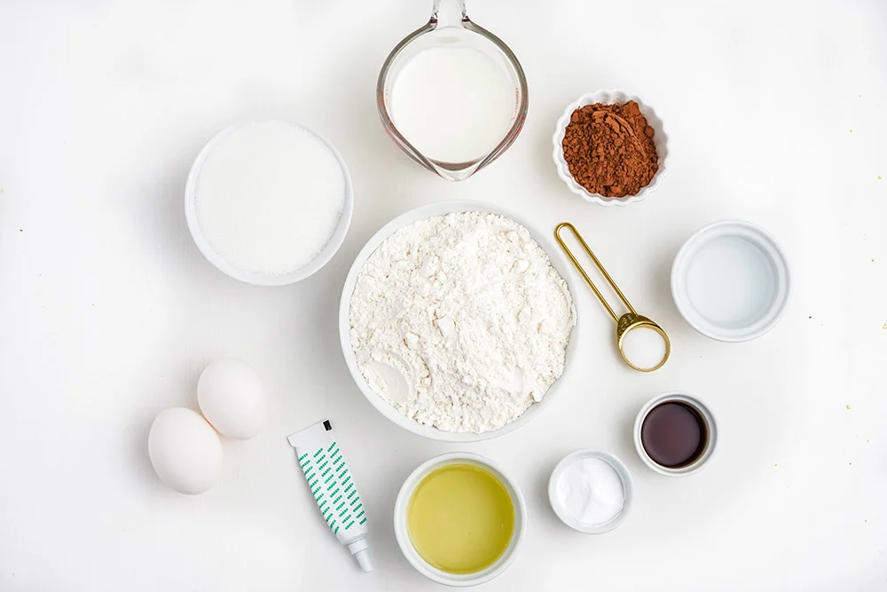 Flour, sugar, eggs, and other ingredients to make cupcakes in bowls. 