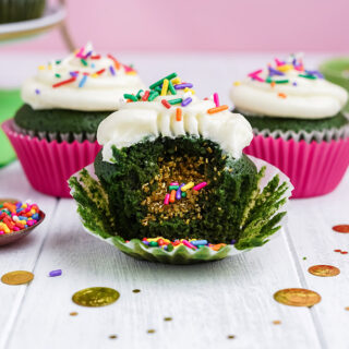 Three green cupcakes with one showing the surprise filling.