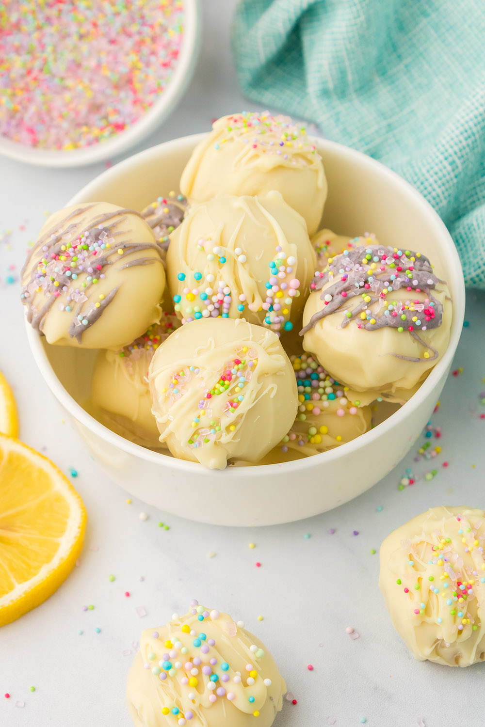 Bowl of yellow oreo truffles with spring colors and sprinkles.