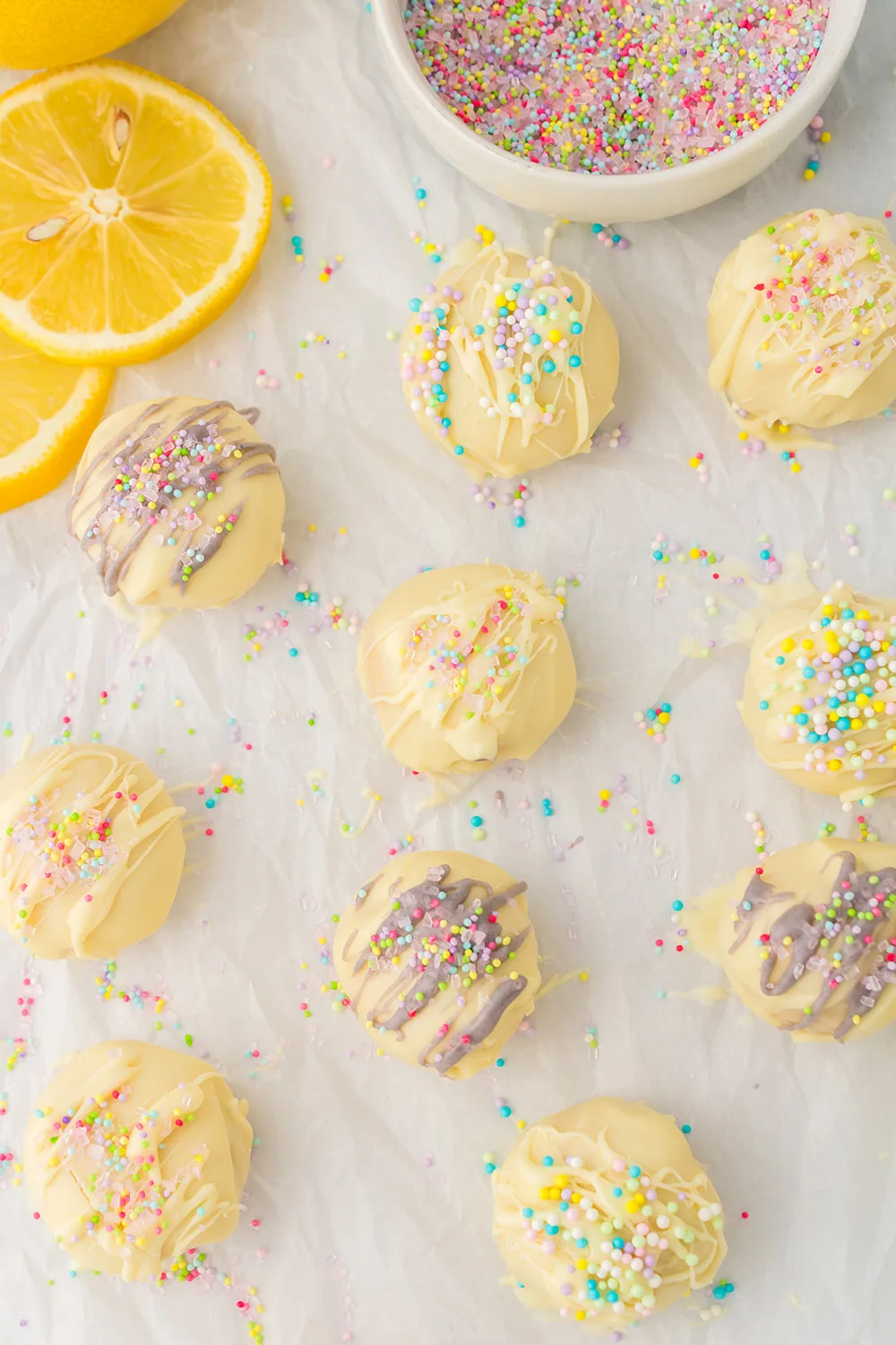 Lemon oreo balls topped with sprinkles on a baking sheet. 